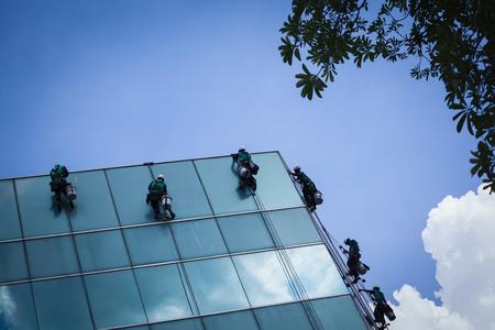 组工人清洗高层建筑上的 windows 服务照片